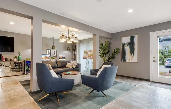 A modern living room with grey chairs and a grey sofa.