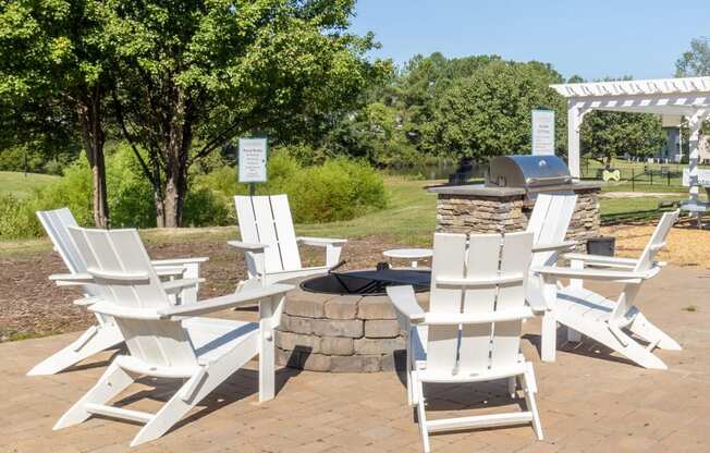 a group of white chairs sitting around a fire pit