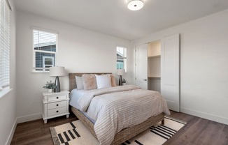 a bedroom with a bed and two windows