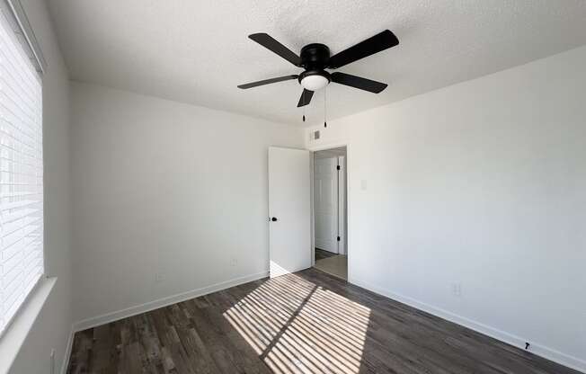 the living room of our studio apartment atrium with a ceiling fan