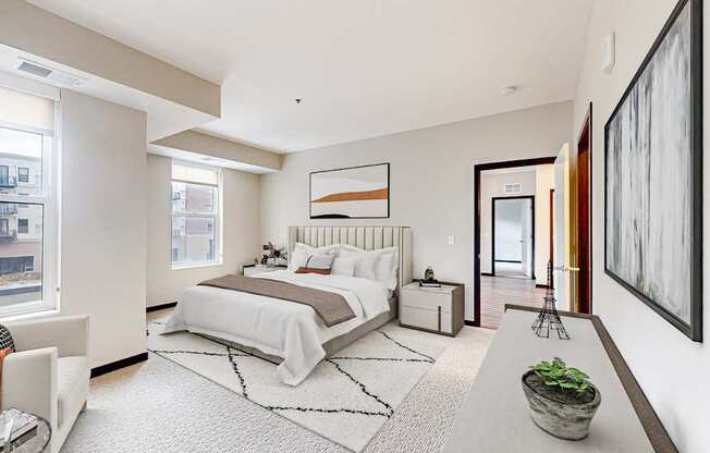 A bedroom with a large bed and a painting on the wall.