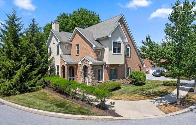 A large house with a grey roof and a stone pillar.