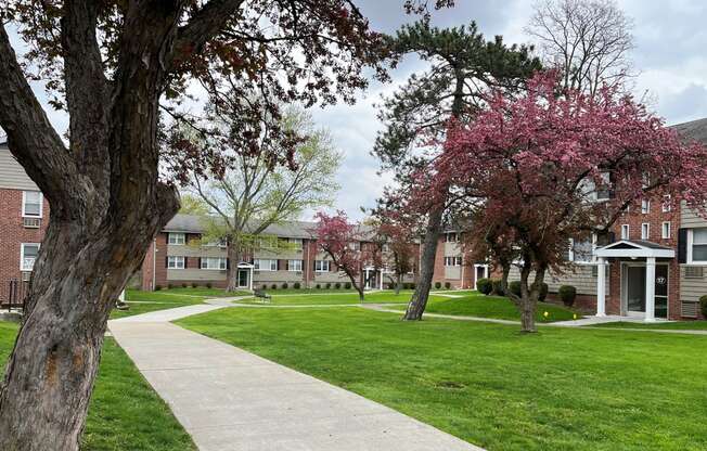 a sidewalk leads through a grassy area in front of a brick building