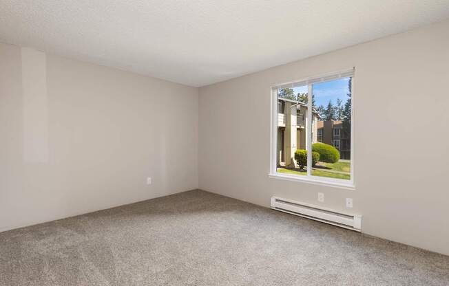 A room with a window showing a building outside.