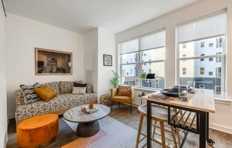 Model living room with a couch and a table and a large window