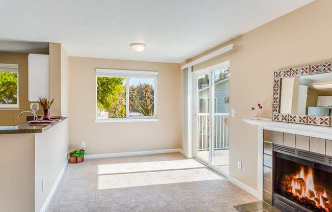 an empty living room with a fireplace and a balcony  at Springfield, Renton, WA