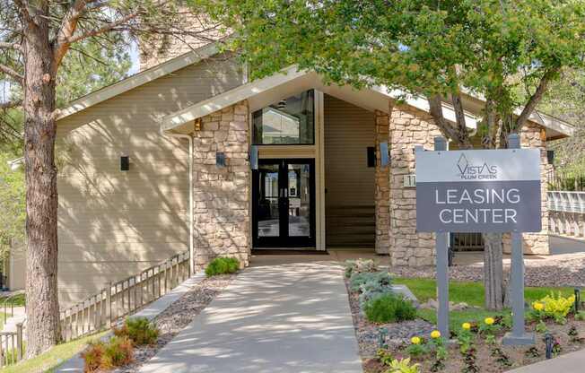 A building with a sign that says "Leasing Center" in front of it.
