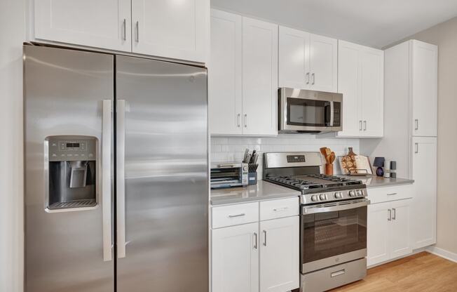 a kitchen with white cabinetry and stainless steel appliances