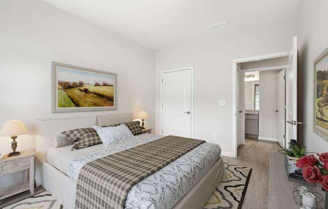 A bedroom with a large bed and a painting on the wall.