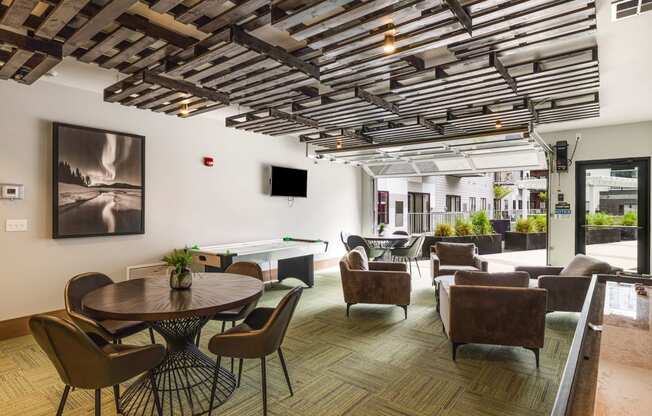 a lounge area with tables chairs and chairs and a television