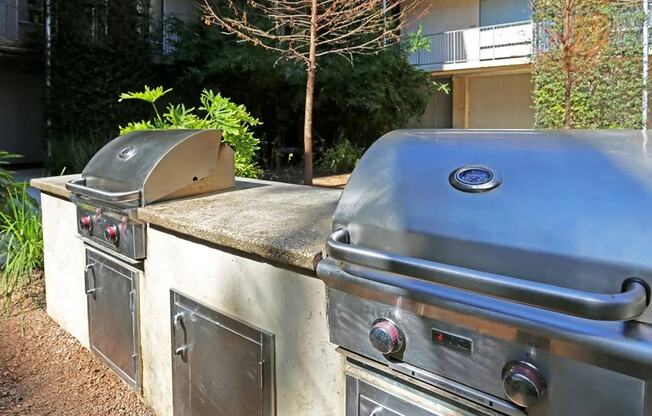 two stainless steel gas bbq grills in an outdoor kitchen