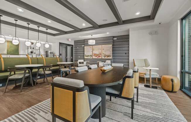A modern clubroom with a large table and chairs.