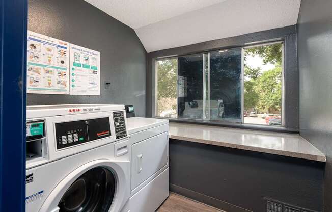 a laundry room with a washing machine and a window