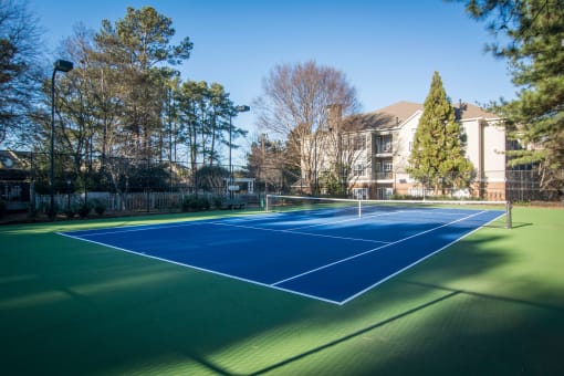 a tennis court with a house in the background at Willowest in Lindbergh, Atlanta, Georgia