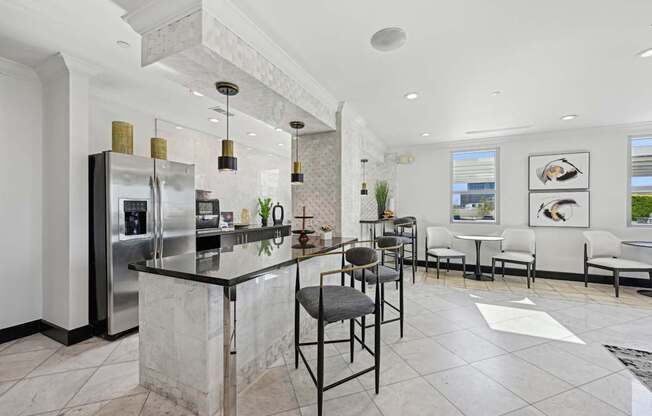 Modern community kitchen with an island and stainless steel appliances for all residents to enjoy at Dominion Post Oak apartments in Houston, TX