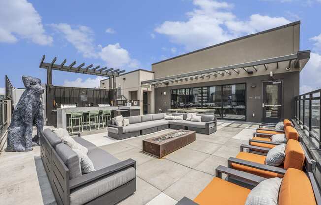 a rooftop patio with couches and a dog statue