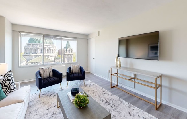 a living room with a large window and a tv on the wall