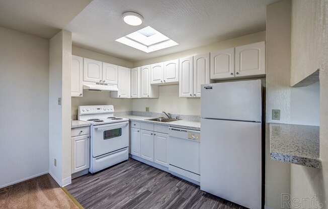 a kitchen with white cabinets and white appliances at Terrace View Apartments, California