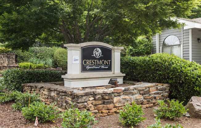 A sign that says Crestmont in front of a house.
