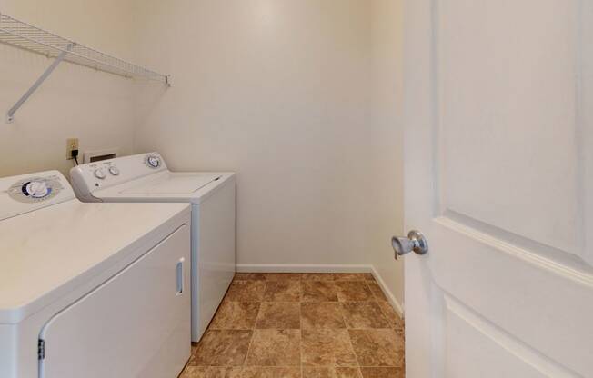 a washer and dryer in a laundry room with a white door