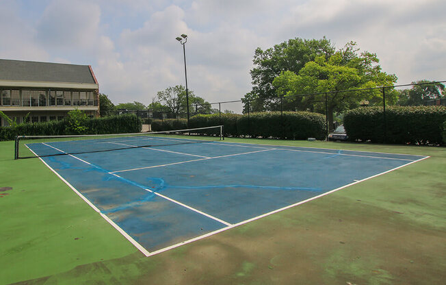 a blue tennis court on a green court