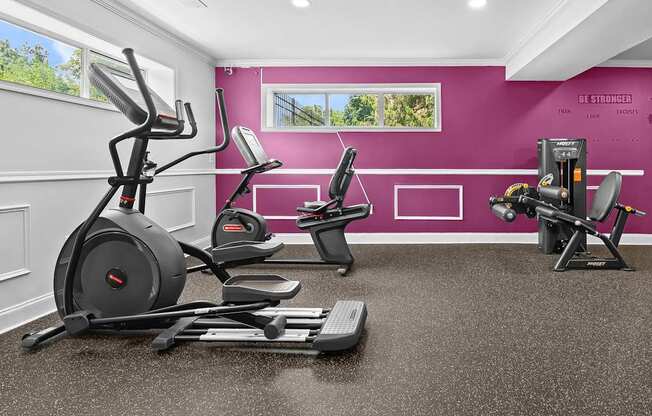 A home gym with a purple wall and exercise equipment.