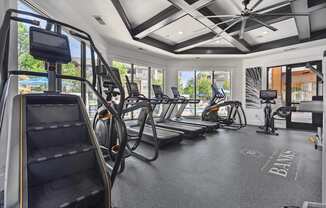 A gym with treadmills, elliptical machines, and a stair climber.