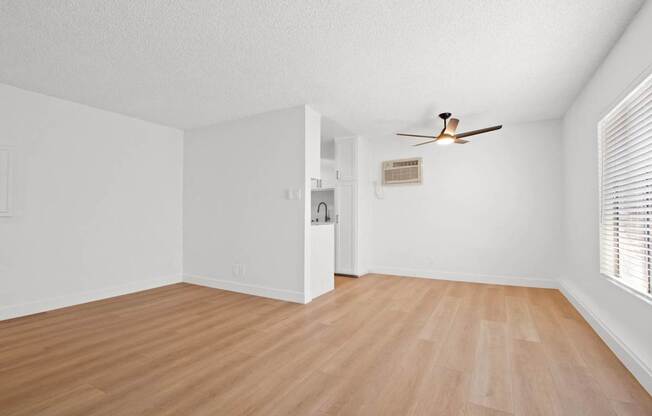 A room with a ceiling fan and light switches on the wall.