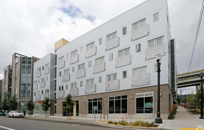 A white building with a grey roof and a black street light in front.