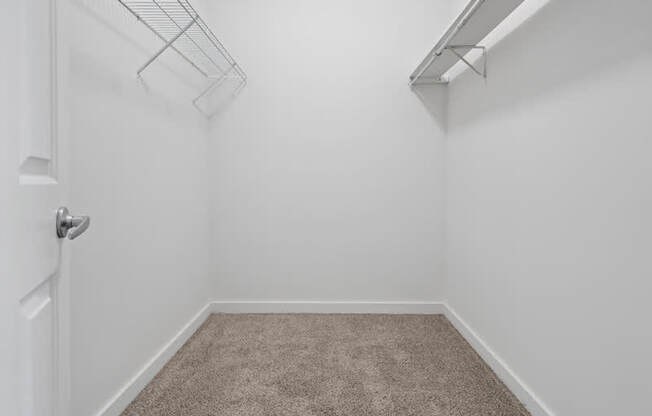 A white room with a carpeted floor and a white door.