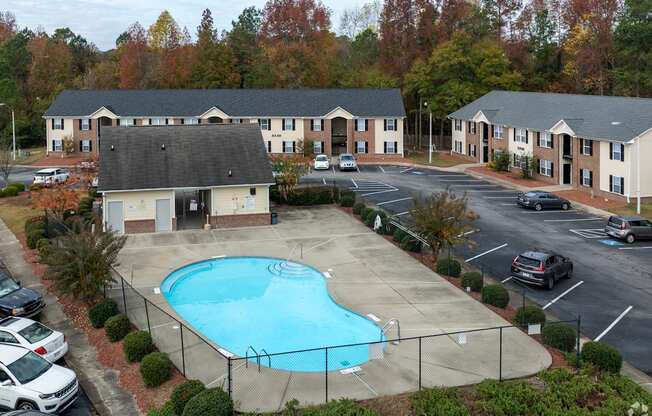 A swimming pool is surrounded by a fence and a building.