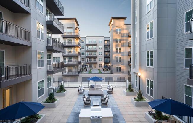 Visit the inviting courtyard with lounge seating, grilling stations, and open-air gathering space at Modera Liberty Row.