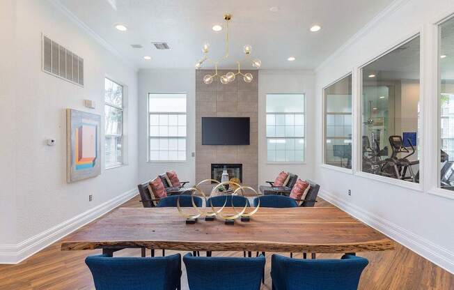 A modern living room with a fireplace and blue chairs.