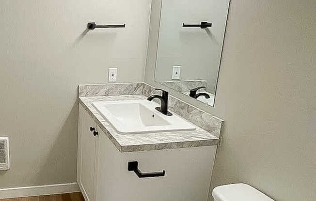 A white toilet sits next to a sink in a small bathroom.