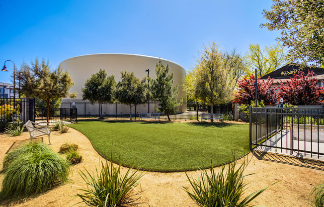 A large white dome-like structure is surrounded by a fence and greenery.