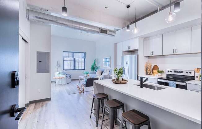 A modern kitchen with white cabinets and a black refrigerator.