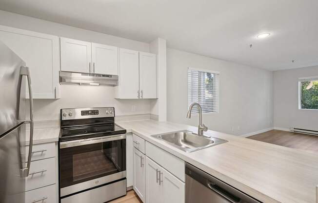 A modern kitchen with stainless steel appliances and white cabinets.
