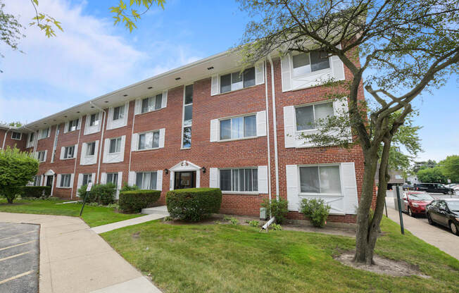 a brick apartment building with a sidewalk in front of it