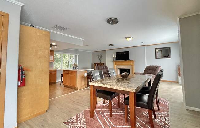 a dining room with a wooden table and chairs and a kitchen with a fireplace