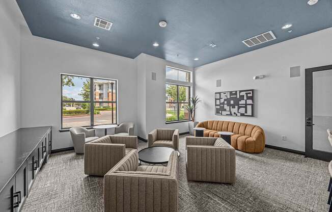 A spacious room with grey carpet and a variety of seating options.