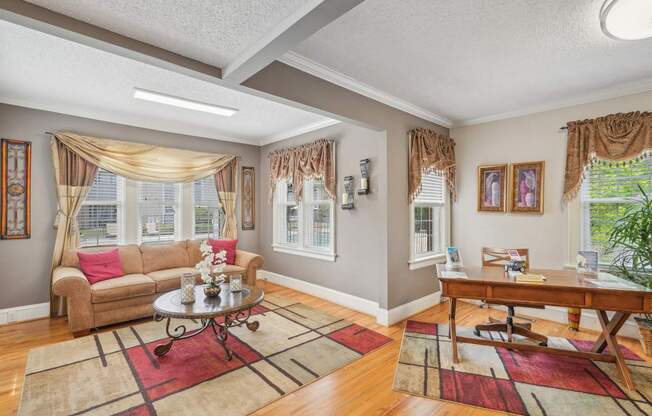 A living room with a couch, coffee table, and a window with curtains.