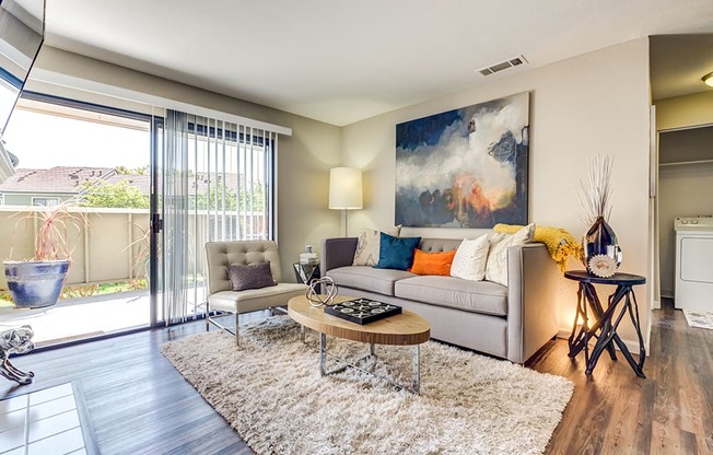 Pittsburg CA Apartments - Open Space Living Room with Stylish Interiors and Hardwood Floor Featuring Sliding Door to Patio