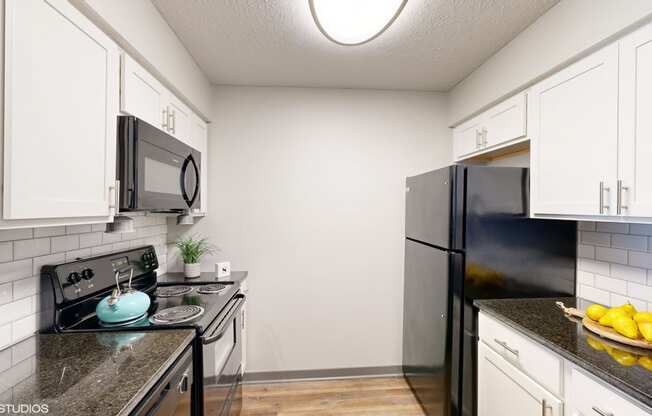 a kitchen with black appliances and white cabinets