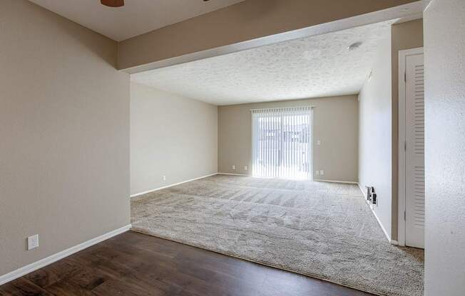 A room with a rug on the floor and a window with blinds. Omaha, NE Evergreen Terrace Apartments