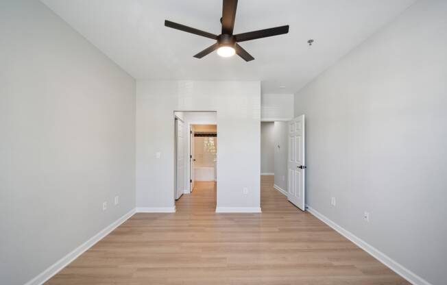 a living room with white walls and a ceiling fan