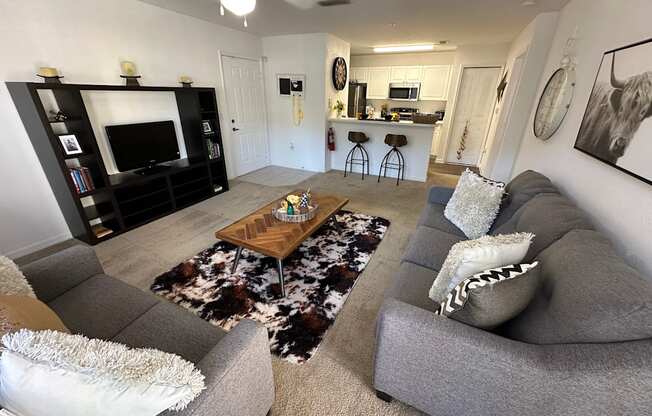 A living room with a grey couch and a wooden coffee table.