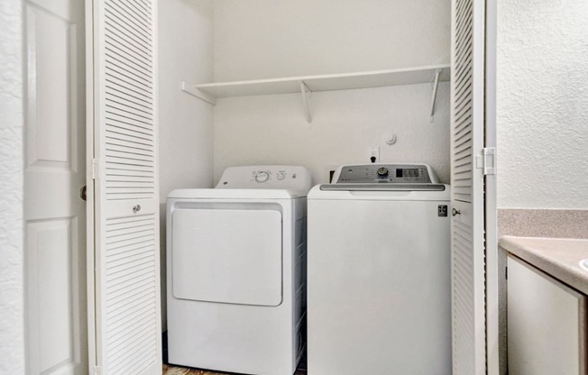 a washer and dryer in a laundry room with a door open