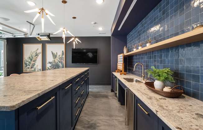 A kitchen with dark blue cabinets and a marble countertop.
