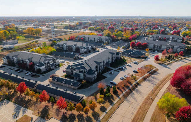 A large building surrounded by trees with autumn leaves.