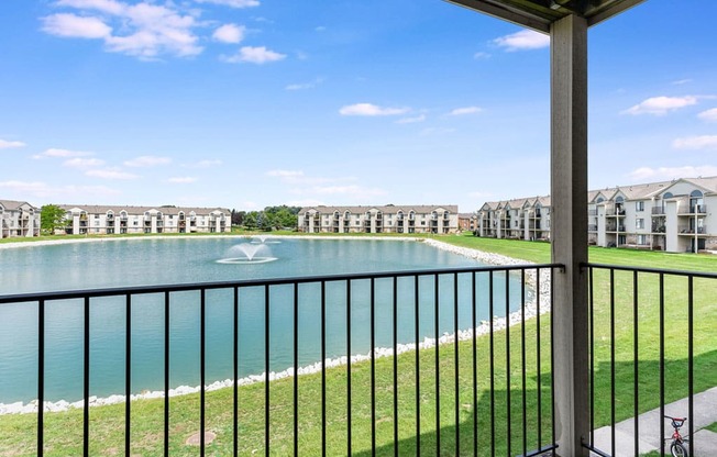 a balcony with a view of a pond with a fountain